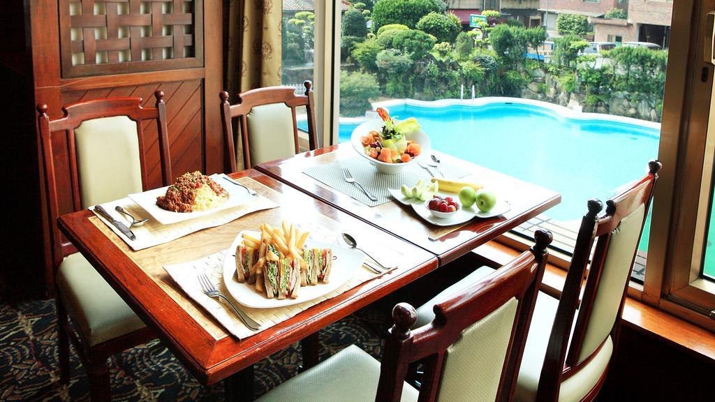The Howard Plaza Hotel Tajpej Kültér fotó A dining table with a view of the pool